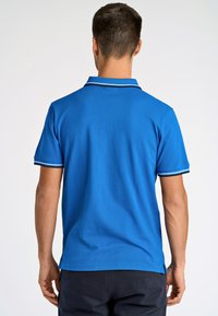 Niebieska koszulka polo o klasycznym designie, z kontrastowym kołnierzykiem i wykończeniem rękawów. Wykonana z teksturowanej tkaniny, idealna na co dzień.