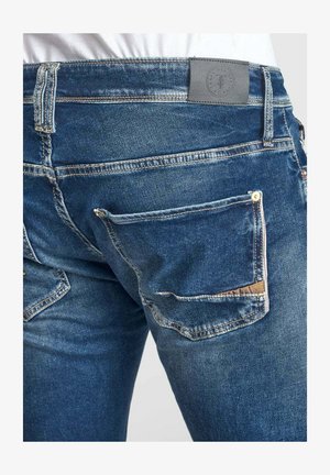 Blauwe denim jeans met een klassiek ontwerp, vijf zakken en een gestructureerde afwerking, met een grijs leren taillebandlabel en contrasterende stiksels.