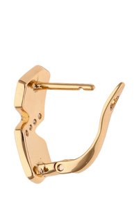 Aranyszínű fém hajcsat geometrikus formával, sima textúrával és diszkrét cirkónia díszítéssel az egyik oldalon. Rugós zárral rendelkezik.