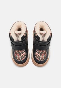 Czarne wysokie botki w kwiatowy wzór z futrzanym wykończeniem, rzepami i brązową gumową podeszwą. Teksturowana tkanina podkreśla szczegóły projektu.