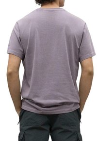 Camiseta de manga corta en tejido de algodón color malva claro, con un clásico escote redondo y un ajuste relajado, vista desde la parte posterior.