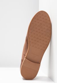 Chaussures marron avec une tige en tissu texturé et une semelle en caoutchouc. Le dessous présente une semelle à motif avec la marque "ANNA FIELD" et la taille 37.