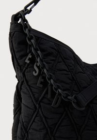 Borsa a spalla nera trapuntata con superficie testurizzata, manico a catena con dettagli a lettere e design minimalista.