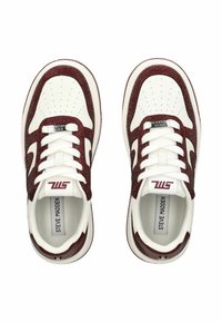 Un paio di sneakers bianche e borgogna di Steve Madden viste dall'alto, caratterizzate da dettagli perforati e lacci bianchi su uno sfondo neutro.