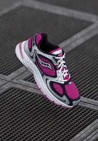 Le sneaker Saucony presentano una tomaia in mesh rosa, nera e bianca con accenti argentati, un collo imbottito e una suola in gomma testurizzata.