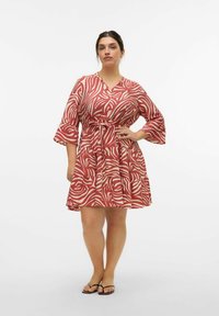 Robe rouge et crème à motifs avec décolleté en V, manches cloche 3/4, taille ceinturée et jupe à volants, fabriquée en tissu léger.