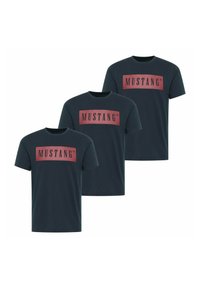 Three dark teal t-shirts made of cotton, featuring a large rectangular red logo with the text "MUSTANG" in black. Short sleeves and crew neck.