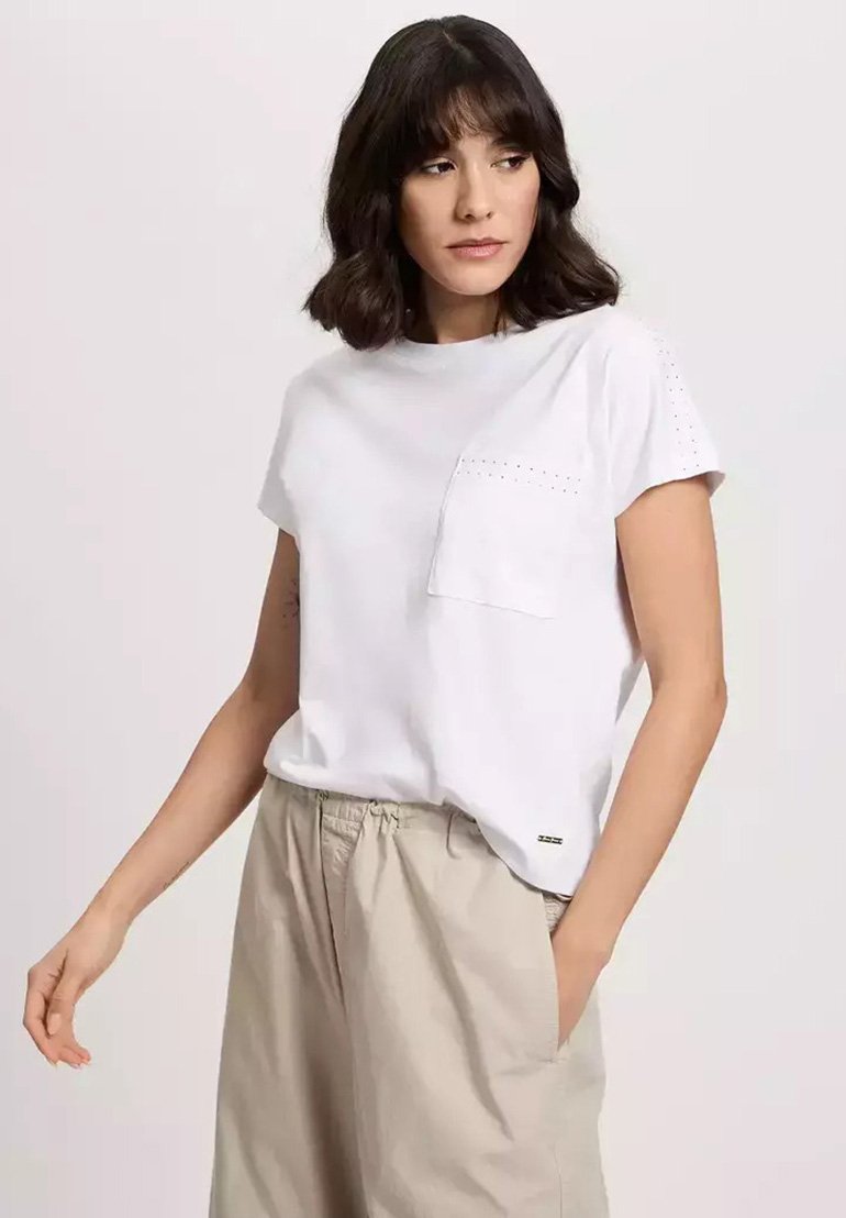 Biała koszulka z krótkim rękawem, wykonana z miękkiej bawełny, z kieszenią na piersi z perforowanymi detalami, zestawiona z beżowymi spodniami z elastycznym pasem.