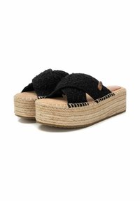 Sandalias de plataforma trenzadas en negro con diseño de tiras cruzadas, suela envuelta en yute y acabado texturizado. Presenta una suela de goma plana.