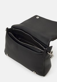 Svart läderväska med en strukturerad yta, med dragkedjestängning och flera inre fack. Silvriga detaljer är synliga.