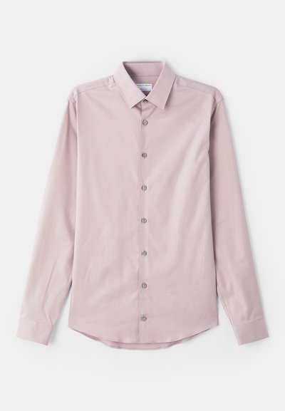 Svetloružová košeľa s dlhým rukávom vyrobená z hladkej textílie. Má golier s gombíkmi a sedem predných gombíkov so striebornými akcentmi. Zakrivený lem.