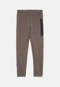 Calças de desporto tapered da Nike numa cor castanha suave, feitas de um tecido macio. Apresentam um bolso lateral com zip e punhos canelados nos tornozelos.
