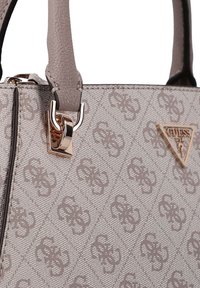 Geantă de mână sintetică gri cu model în relief, prevăzută cu o închizătoare și un logo aurii. Mânere duble cu prindere texturată.