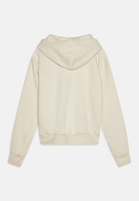 Hoodie di colore crema con cappuccio regolabile, polsini e vita a costine. Texture del tessuto liscia, mostrato da dietro.