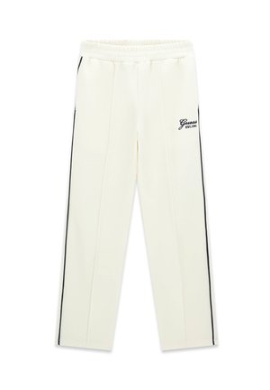 Witte joggingbroek met zwarte zijstrepen en elastische tailleband, met het "Guess EST.1981" logo op het bovenste linkerbeen.