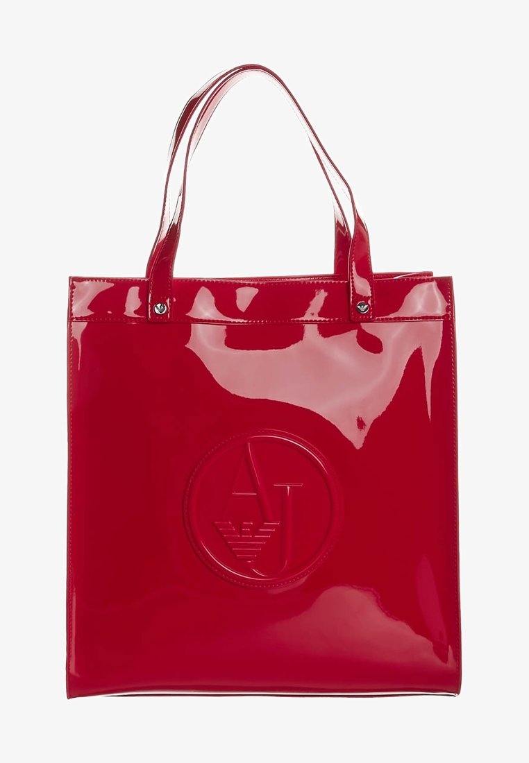 Röd, blank PVC-väskan med två handtag, med en cirkulär präglad logotyp i mitten. Mjuk textur och slank design.