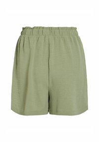 Shorts vert clair, amples, avec une taille élastique, fabriqués en tissu texturé, avec des bords non ourlés pour un look décontracté.