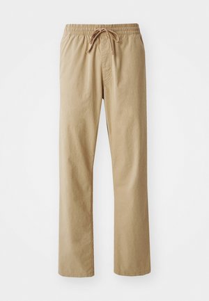 Jasno beżowe spodnie z elastycznym paskiem w talii i sznurkiem do ściągania. Wykonane z miękkiego materiału, mają proste nogawki i gładką fakturę.