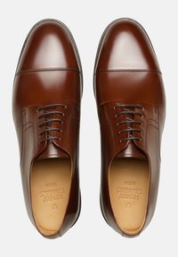 Braune Lederhalbschuhe mit glatter Oberfläche, mandelförmiger Zehenpartie und Schnürdesign. Mit dezenten Steppnähten und gepolsterter Innensohle.