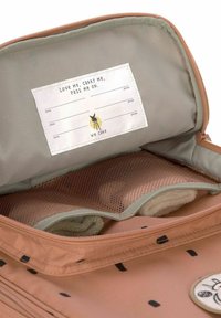 Rosa Kulturbeutel aus Segeltuch mit Netztasche, innerem Etikett zur Personalisierung und schwarzem Punktmuster. Reißverschluss mit abgerundeten Kanten.