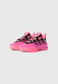 Chaussures de sport avec un design noir et rose, présentant une semelle texturée, une languette rembourrée et des lacets et accents roses contrastants.