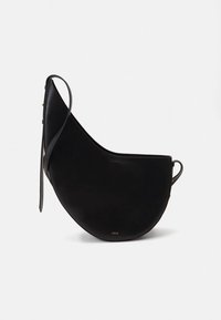 Black leather shoulder bag with a curved, half-moon shape, slim strap, and minimalistic design. Smooth texture with subtle gold hardware.