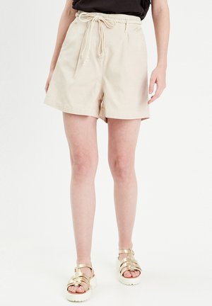 Pantaloni corti in cotone beige con vestibilità rilassata, cinturino elastico in vita e chiusura con coulisse. Presentano tasche laterali e orlo piatto.