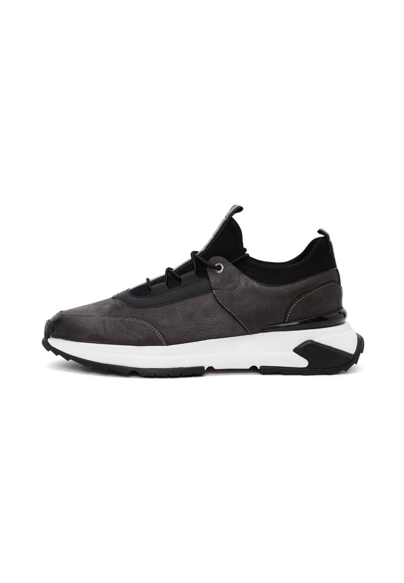 Sportowe sneakersy z szarą skórzaną cholewką i czarną tekstylną górą, z teksturowanymi akcentami i białą podeszwą środkową. Solidna czarna gumowa podeszwa zewnętrzna.