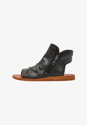 Zwarte leren open teen sandalen met gekreukt textuur, zijritsen en een minimalistische houten zool. Beschikt over een asymmetrisch ontwerp.