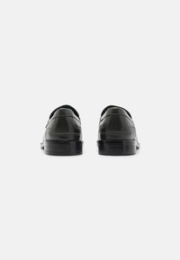 Schwarze Lederhalbschuhe mit glatter Oberfläche, abgerundetem Zehenbereich und niedrigem Absatz. Seitennähte und minimalistisches Design mit einem bequemen Schlüpföffnungs.