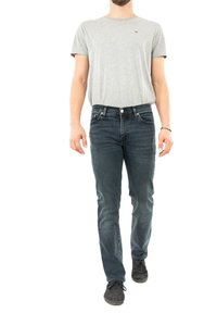 T-shirt grigia a maniche corte abbinata a jeans in denim blu scuro, con una vestibilità slim. Sneakers nere completano l'outfit.