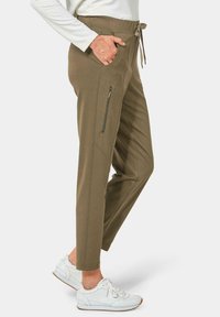 Olivgrüne Jogginghosen mit lässigem Schnitt, elastischem Taillenbund, Kordelzug, Seitentaschen und einer mit Reißverschluss versehenen Oberschenkeltasche. Strukturierter Stoff.