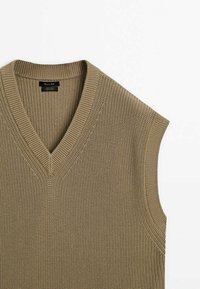 Beige knitted sleeveless sweater vest with V-neck and ribbed collar and armholes, made of 100% cotton.