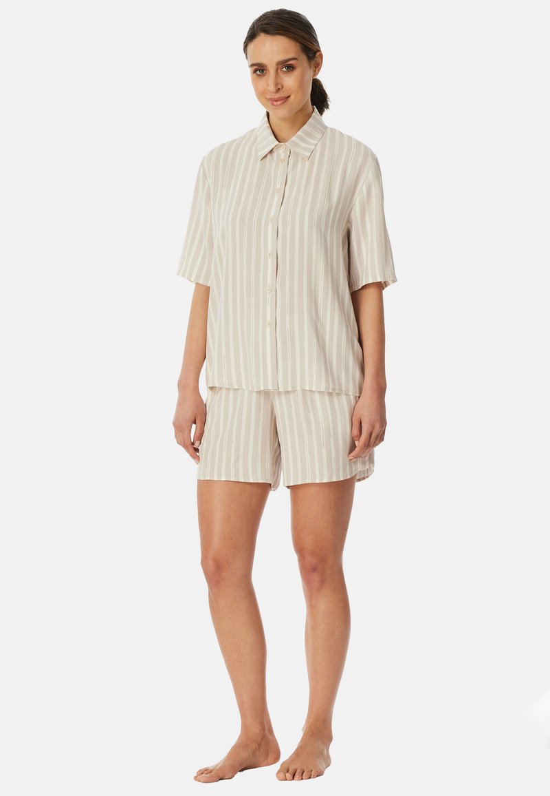 Korte mouwen, knoopsluiting pyjama set in licht beige met dunne verticale strepen. Zachte, lichte stof; inclusief bijpassende shorts.