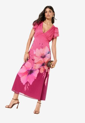 Lange bloemenjurk in roze tinten, met een diepe V-hals, geplooide mouwen en een vloeiende rok met grote, opvallende bloemenpatronen.