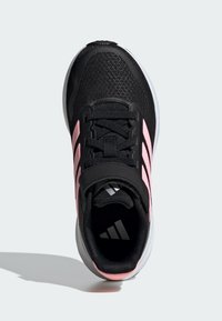 Black athletic shoe with pink accents, textured mesh upper, and white rubber sole. Features laces and three stripes logo detail.