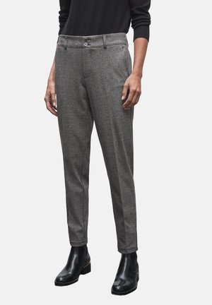 Pantaloni grigi a quadri con una vestibilità sartoriale, piega frontale singola e due tasche anteriori, indossati con stivaletti neri alla caviglia. Texture liscia.