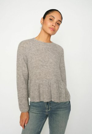 Gray sweater made of soft knit fabric, features a peplum hem, long sleeves, and a round neckline. Paired with light blue jeans.