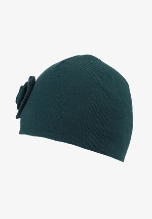 Dark green knitted beanie hat with a small decorative fabric flower on the side, displayed on a white background.