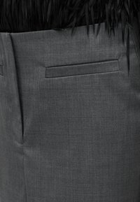 Pantalon gris sur mesure avec un design élégant, un tissu texturé, des poches latérales et une silhouette droite.