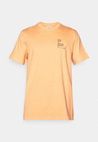 T-shirt en coton orange à manches courtes, col rond, et design de texte à l'avant : "TOUT LA JOURNÉE JE RÊVE DE S." Texture lisse, coupe décontractée.