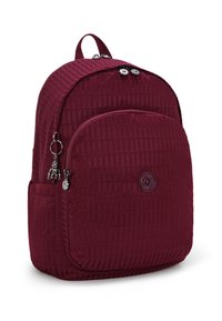 Vinröd nylonryggsäck med quiltad textur, cirkulär logotyp framtill och två fack med dragkedja. Utrustad med silverfärgade detaljer.