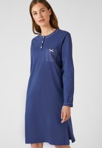 Abito lungo a maniche lunghe di colore blu navy in cotone. Presenta un collo a polo, una fila di bottoni, una tasca a pois e dettagli decorativi sulle maniche.