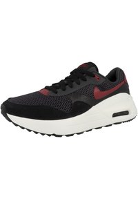 Svarta och röda atletiska sneakers med ett meshnät, mocka accenter, en tjock vit sula och en synlig luftenhet i hälen.