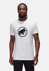 Witte t-shirt met korte mouwen met een grote zwarte mammoetafbeelding binnen een cirkelvormige omtrek op de voorkant. Gladde katoenstof.