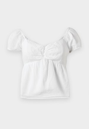 Bela bomba bluzica s puf rukavima, zbrana u struku i s zakrivljenim izrezom. Mekana tekstura i glatka obrada s lepršavim rubom.