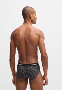 Herreboxershorts i et geometrisk sort og gr�åt mønster med en ensfarvet sort talje, der har hvide accentstriber.