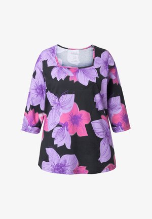 Schwarze Tunika mit dreiviertellangen Ärmeln, versehen mit großen lila und pinken Blumenmustern auf einem strukturierten Stoff, quadratischer Ausschnitt.
