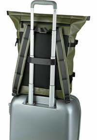 Grüner Rucksack mit verstellbaren Trägern, Netzrücken und Reißverschluss, montiert auf einem strukturierten silbernen Koffer mit Rollen und doppelten Griffen.