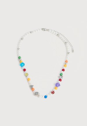 Κολιέ με λευκές πέρλες, πολύχρωμες χάντρες, ασημένια καρδιά και ζάρια ως γούρια, και ασημένια αλυσίδα κούμπωμα σε λευκό φόντο.